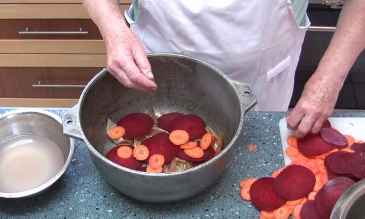 At the bottom of a large pot or cauldron, lay onion husks, and then vegetables.