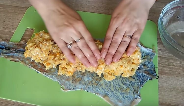 We spread the pike skin on the board and distribute the minced meat on it.