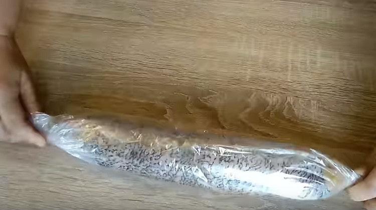 We place the stuffed pike in the culinary sleeve for baking, wrap, fasten the edges.