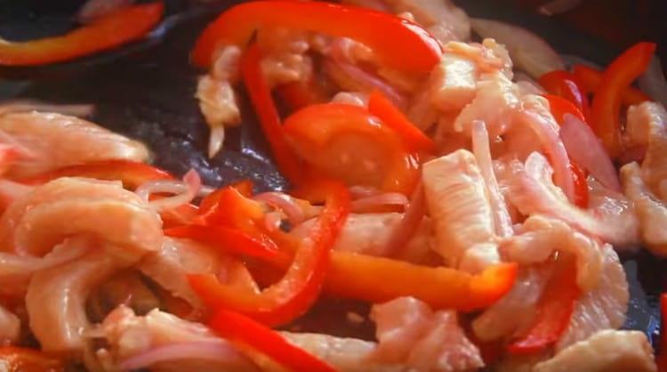 Next, add the chicken and fry for several minutes.