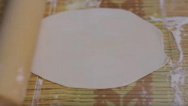 We roll each piece of dough into a thin cake.