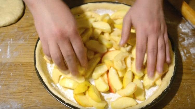 Spread apples sliced in slices and evenly distribute over the dough.