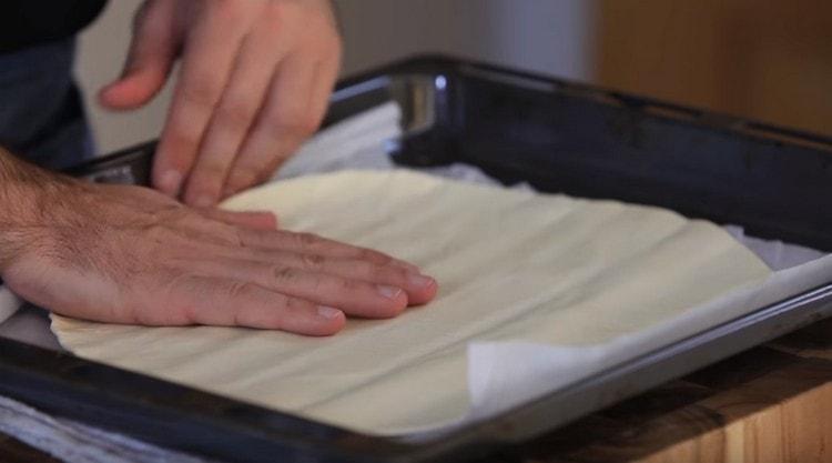 On a baking sheet, lay out a sheet of finished puff pastry.