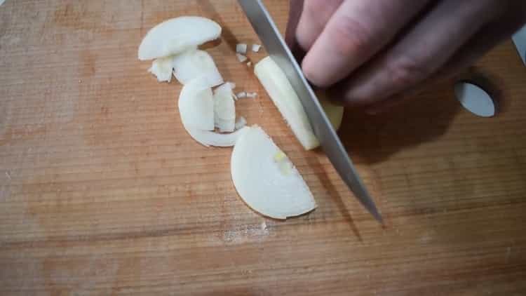 To cook beef stew with vegetables, chop the onion