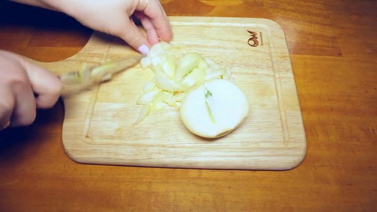 To cook beef goulash in a slow cooker, chop onions
