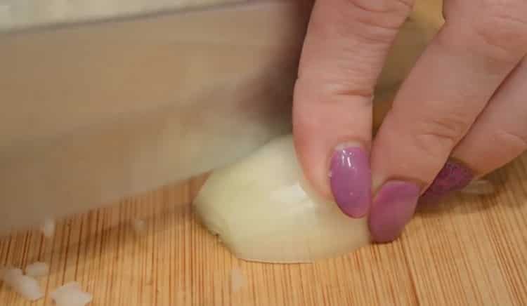 To make crab stick cutlets, chop the onion