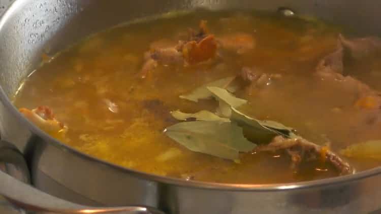 To cook the stewed rabbit with potatoes, add spices and bay leaf