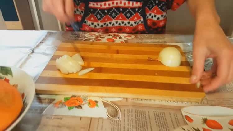 To cook a stewed rabbit with vegetables, chop the onion