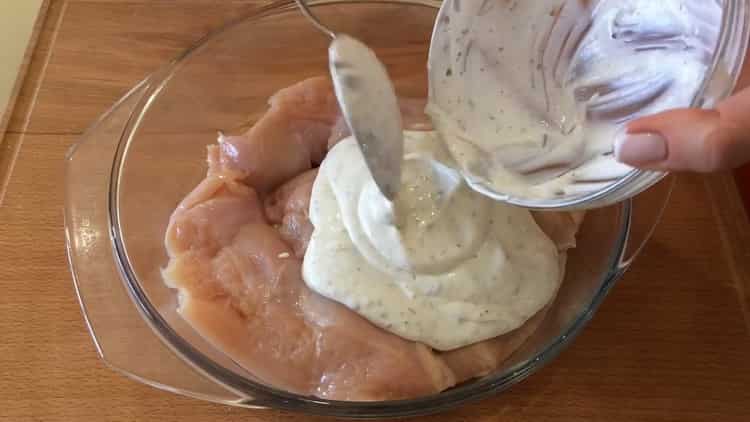 To cook chicken breast with potatoes in the oven, marinate the meat