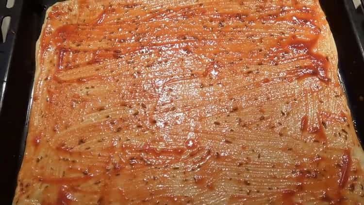 To make the pizza toppings, put the sauce on the dough