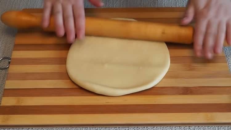 Roll out the dough to make a mushroom pie in the oven