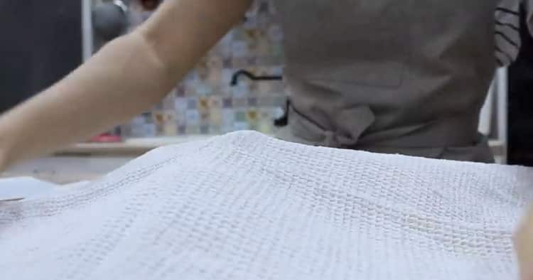 To make 4 cheese pizza, cover the dough with a towel.