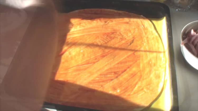 Put ketchup on the dough to make assorted pizza