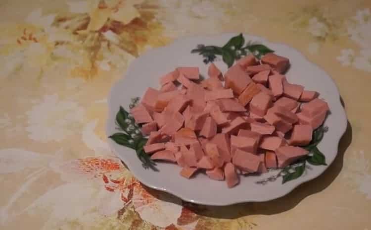 To make pizza with sausage and cheese, cut the sausage