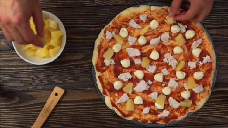 To prepare pizza with chicken and pineapple, lay the filling on the base