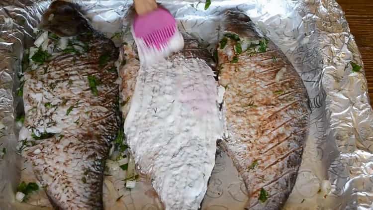 To cook fish on sour cream in the oven, coat the fish with sour cream