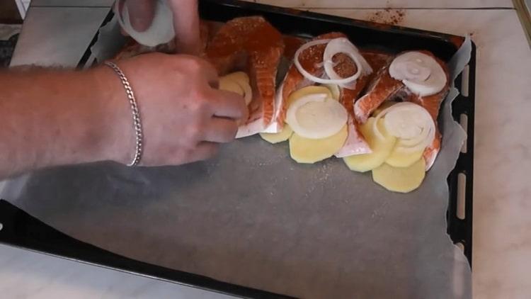 To cook salmon with potatoes in the oven, chop the onion
