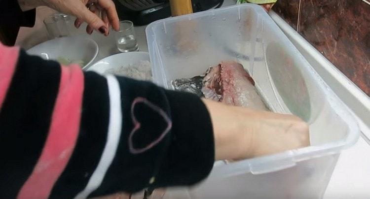 We spread the first piece of fish and grease it with the prepared mixture for salting.