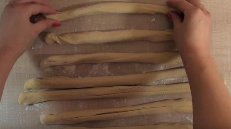 We roll each piece of dough into a thin tourniquet.