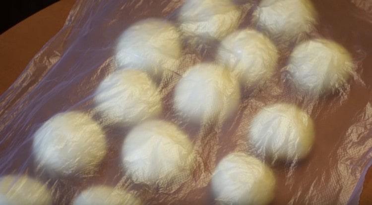 We cover the balls of dough with cling film and let them rise.