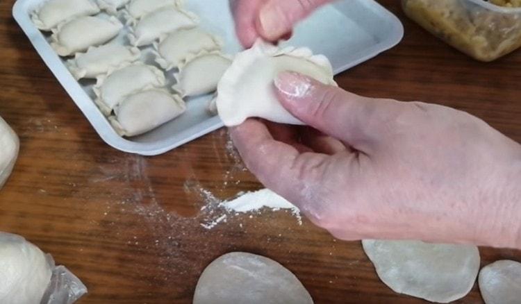 We pinch the edges of the dough, forming dumplings.