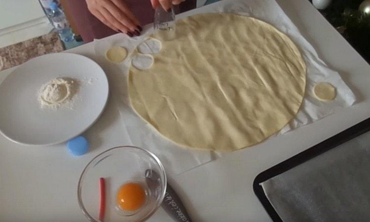 With a cookie cutter or a glass, we cut circles out of the dough layer.