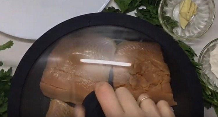 We lay out the slices of pink salmon in a pan and fry under the lid.