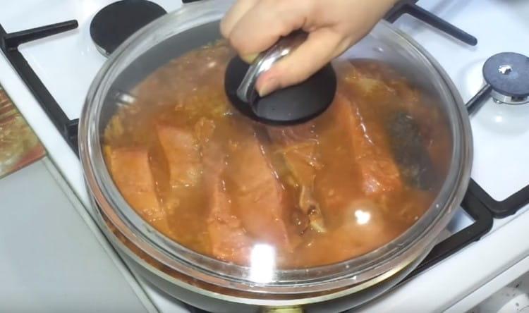 Cover the fish with vegetables with a lid and leave to stew.