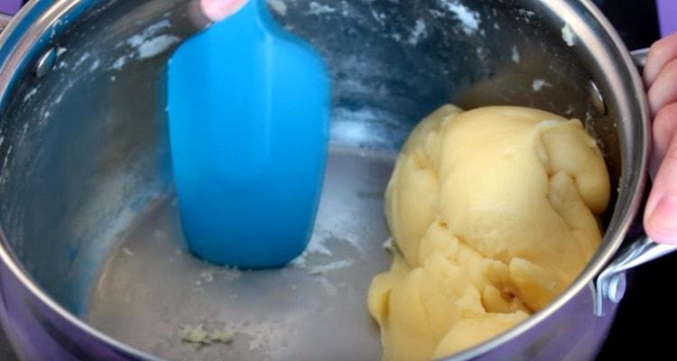On low heat we keep the stewpan with the dough and constantly mix until the flour begins to stick to the walls of the pan.