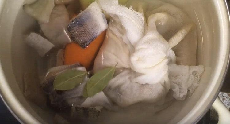 We fill the knot with the remains of fish, the slices themselves, as well as onions, peas, peas, carrots and bay leaves with water in a saucepan.