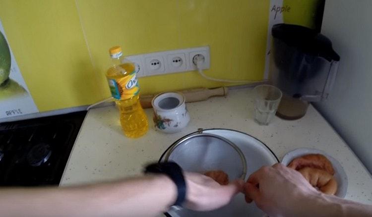 Hands rub the caviar through a sieve.