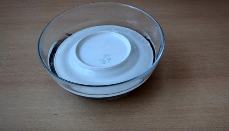 Cover the capelin with a plate and leave to marinate.