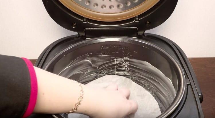 We line the bottom of the greased multicooker bowl with a sheet of parchment.
