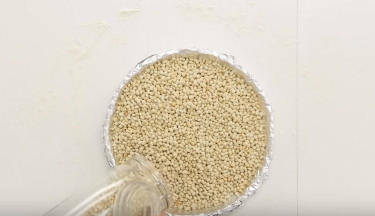 Covering the dough with foil, pour on non-beans so that the dough does not rise when baking.