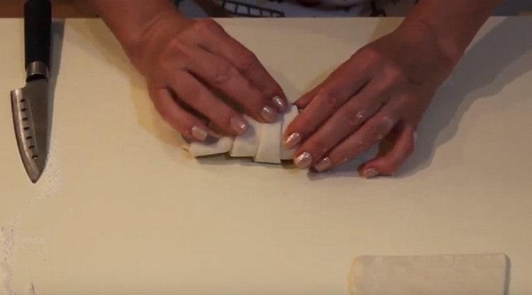 Gently roll the dough towards the narrow end, forming a croissant.