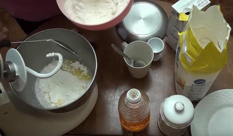 Add part of the flour and turn on the combine to mix the dough.