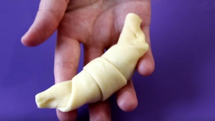 We roll the dough with a roll, forming croissants.