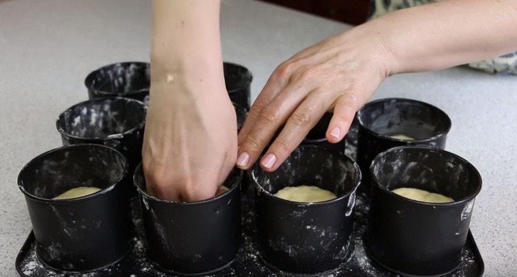 We distribute the dough into forms, rounding each piece.