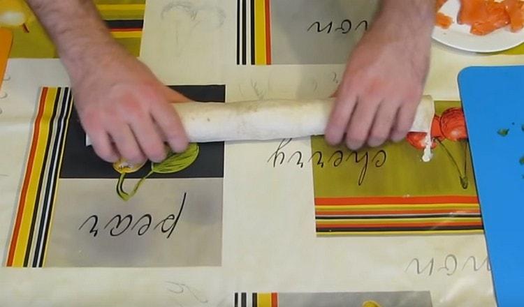 Gently roll the pita bread into a tight roll.