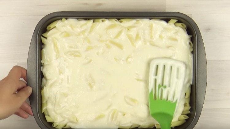 Cover the pasta with half a bechamel sauce.