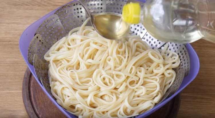 Throw spaghetti into a colander and flavored with vegetable oil.