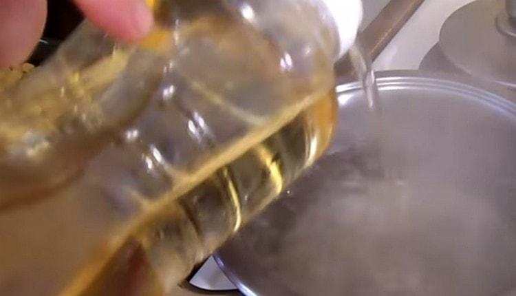 In a saucepan, bring the water to a boil, add vegetable oil to it.