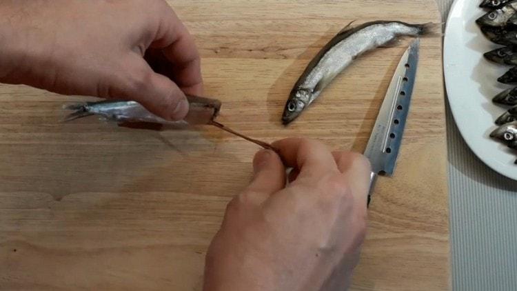 Cut off the fish head and pull out the insides.