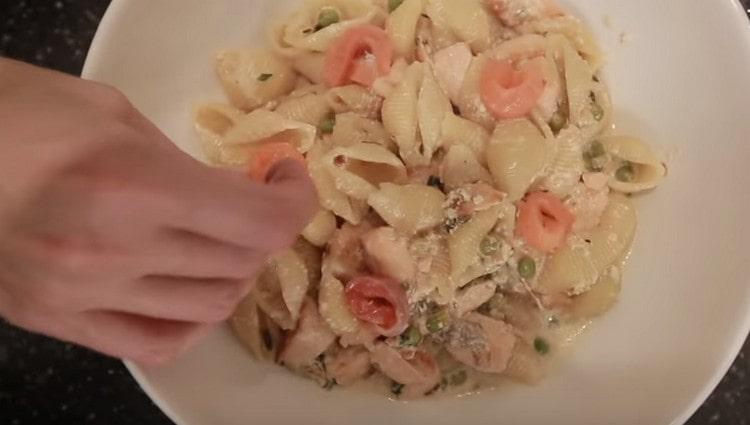 When serving, decorate pasta with salmon in a creamy sauce with slices of slightly salted fish.