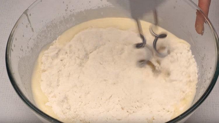 In parts, we begin to introduce flour and knead the dough.
