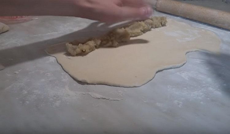 Along the dough on one side, spread the potato filling.