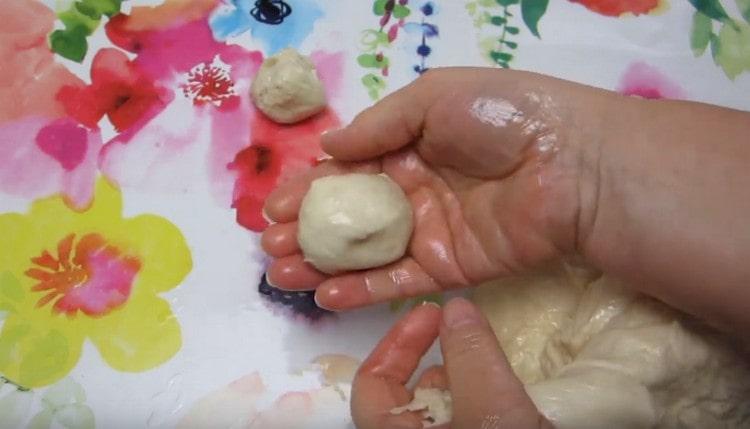 We spread the dough on a table greased with vegetable oil and make small balls out of it.