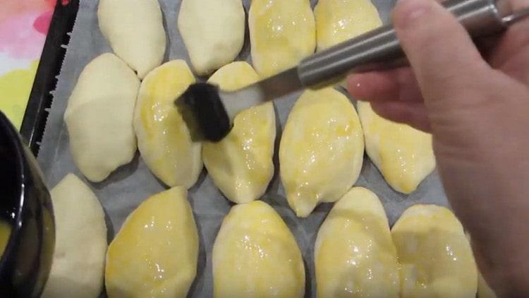 Grease the pies with whipped yolk.