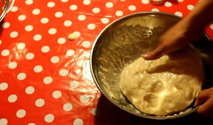 Having greased hands with vegetable oil, we separate the dough from the walls of the bowl.