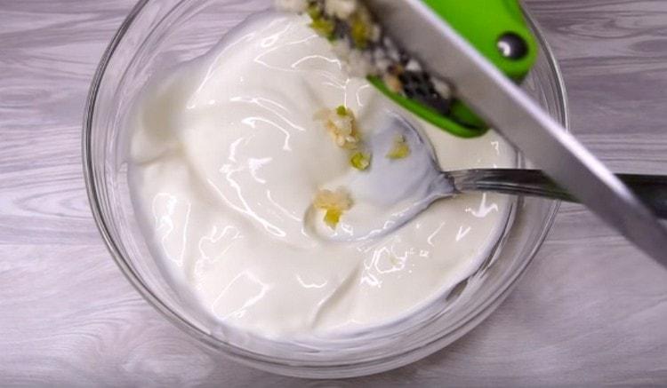 To make the sauce, mix sour cream with chopped garlic.